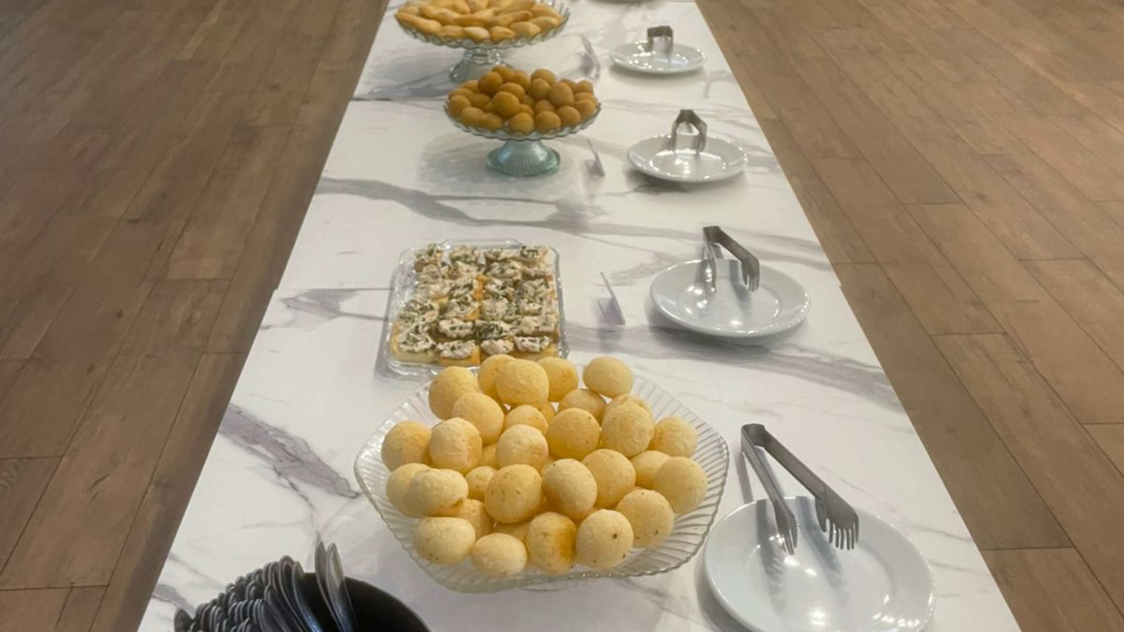 Mesa de buffet com opções de salgados, bolos, frutas e bebidas quentes e geladas