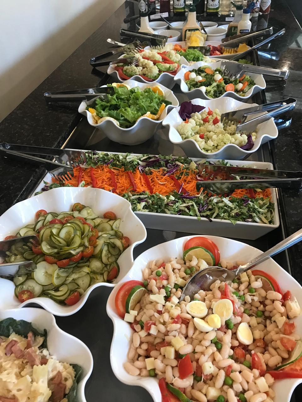 Buffet de saladas com 10 opções com verduras, legumes e frutas servidas em cuba refrigerada